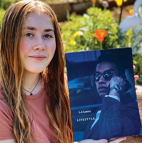 Freshman digital media and visual effects major Kyleigh Sanchez poses with a magazine she designed in a photography class. 