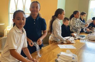 Michael Langi and Welshdon Lolo work with other Riverview students to bag over 400 pairs of socks to help the homeless.