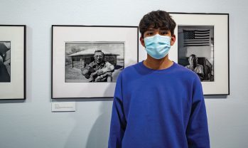 Nathaniel stands next to a photo of his grandfather (left) who was a Navajo Code Talker.